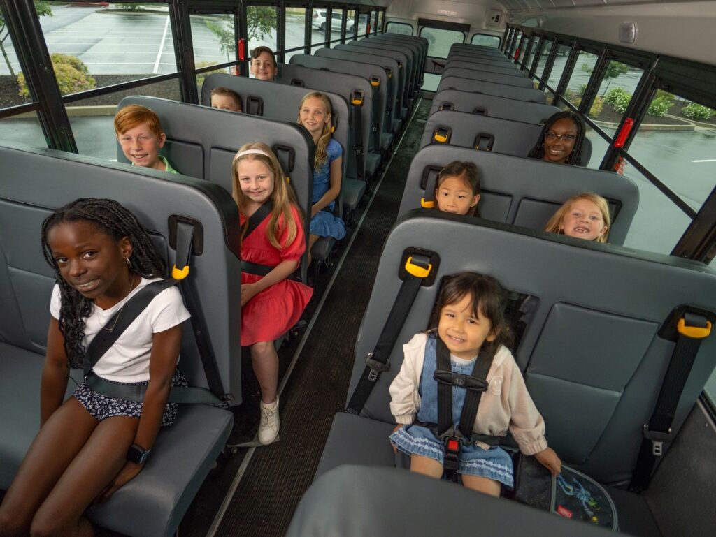 This is a Blue Bird school bus with every kid restrained by an IMMI seat belt or harness.